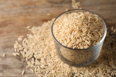 Photo of Brown rice in glass on table. Space for text