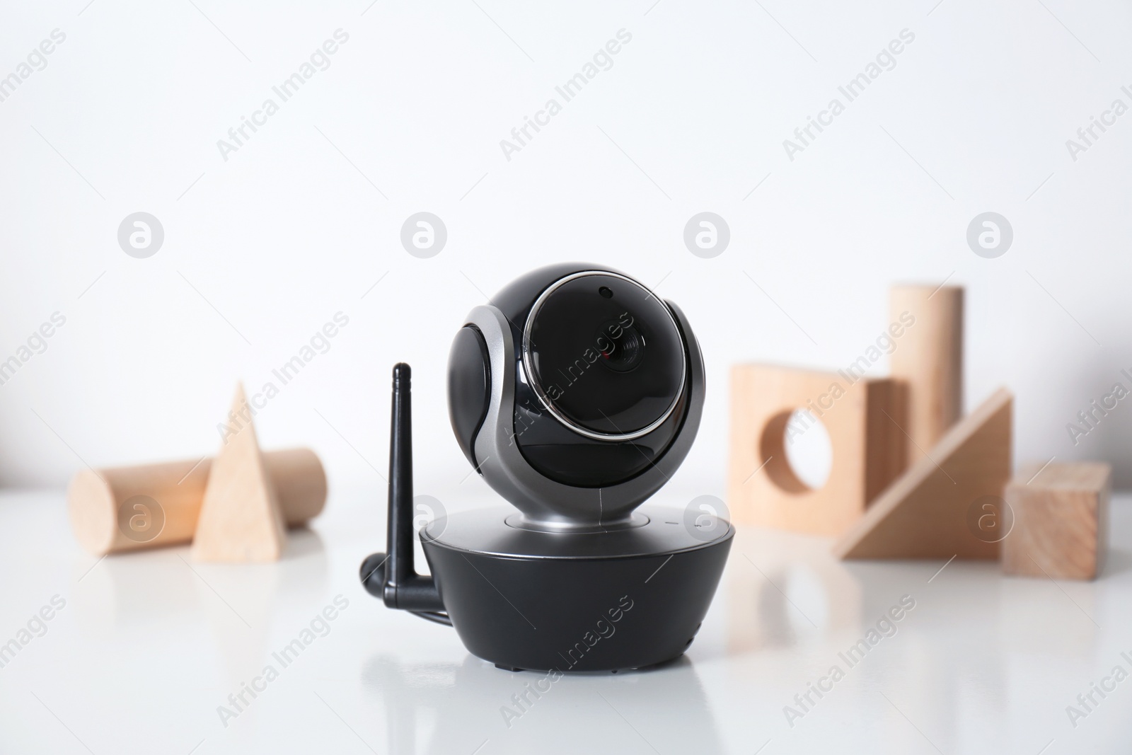 Photo of Modern CCTV security camera and wooden blocks on table