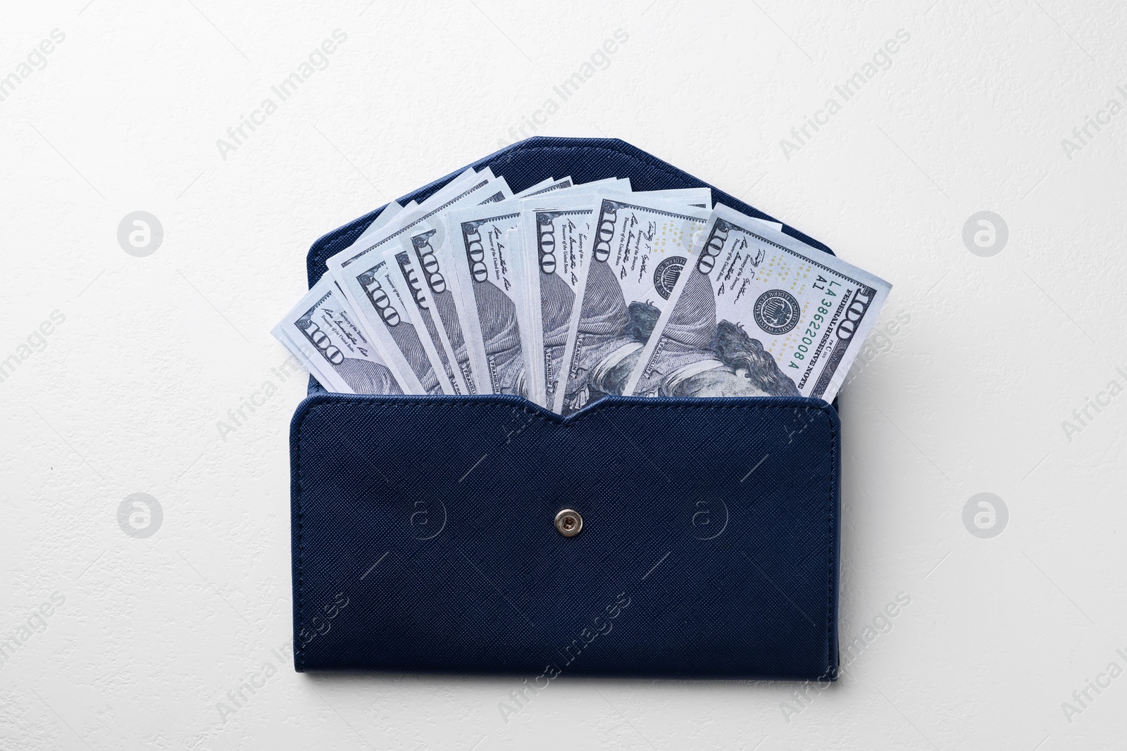 Photo of Dollar banknotes in wallet on white table, top view. Money exchange