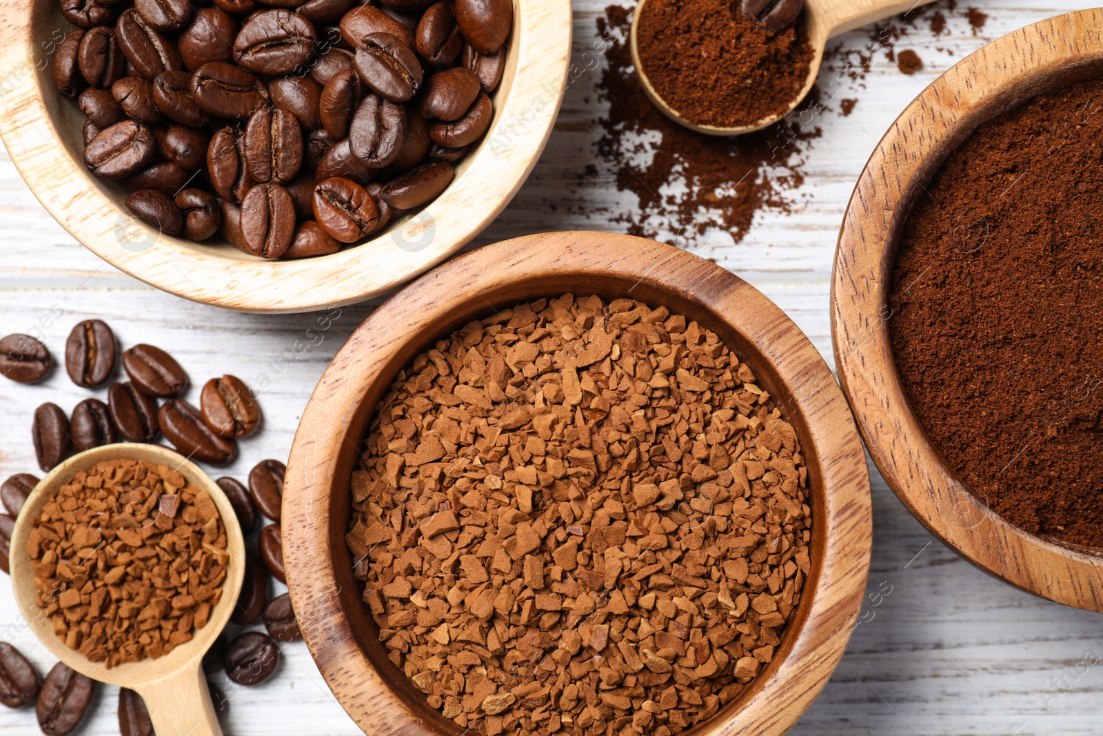 Photo of Instant, ground coffee and roasted beans on white wooden table, flat lay