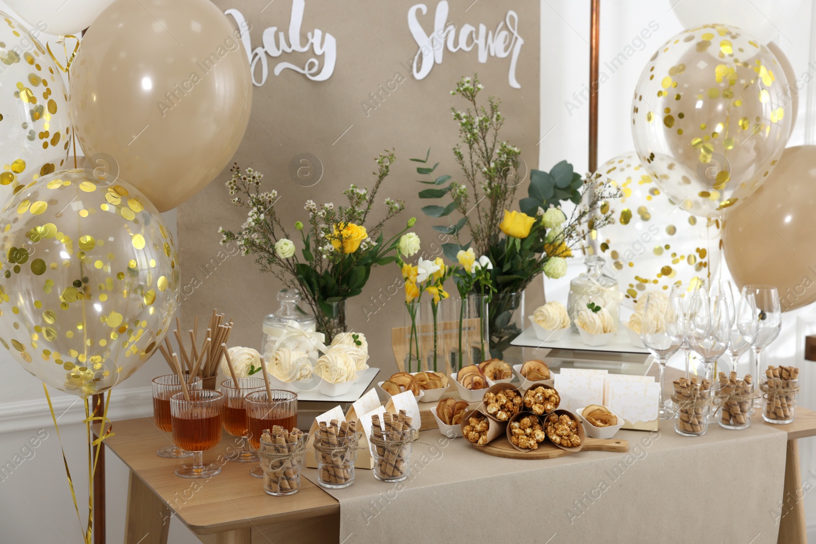 Photo of Tasty treats and glasses of drink on table in room. Baby shower party