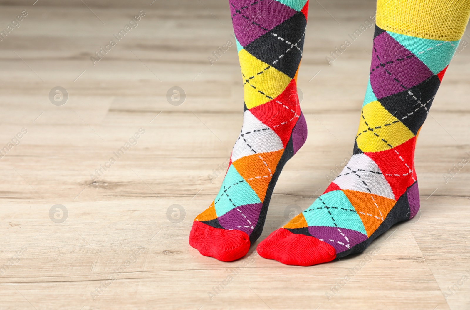 Photo of Woman wearing stylish socks standing on floor. Space for design