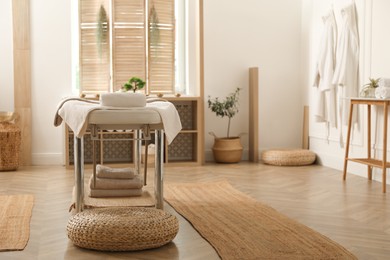 Photo of Stylish massage room interior with spa table in salon