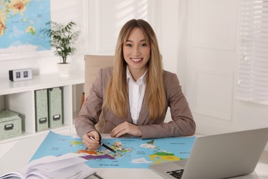 Photo of Happy manager working at desk in travel agency