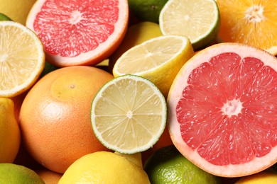 Different fresh citrus fruits as background, closeup