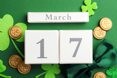 Photo of Flat lay composition with wooden block calendar on green background. St. Patrick's Day celebration