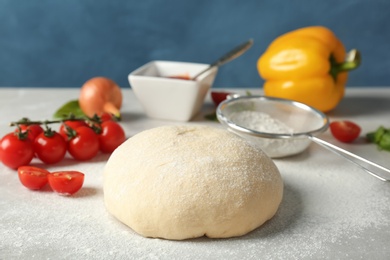 Photo of Fresh dough and ingredients for pizza on table