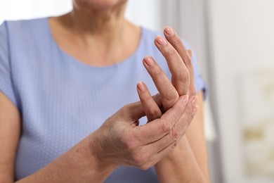 Photo of Arthritis symptoms. Woman suffering from pain in hand at home, closeup