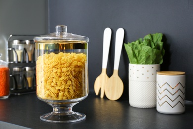 Photo of Pasta in modern kitchen glass container on black table