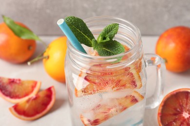 Photo of Delicious refreshing drink with sicilian orange and mint on grey table, closeup