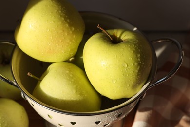 Photo of Fresh wet apples in colander on dark background, closeup