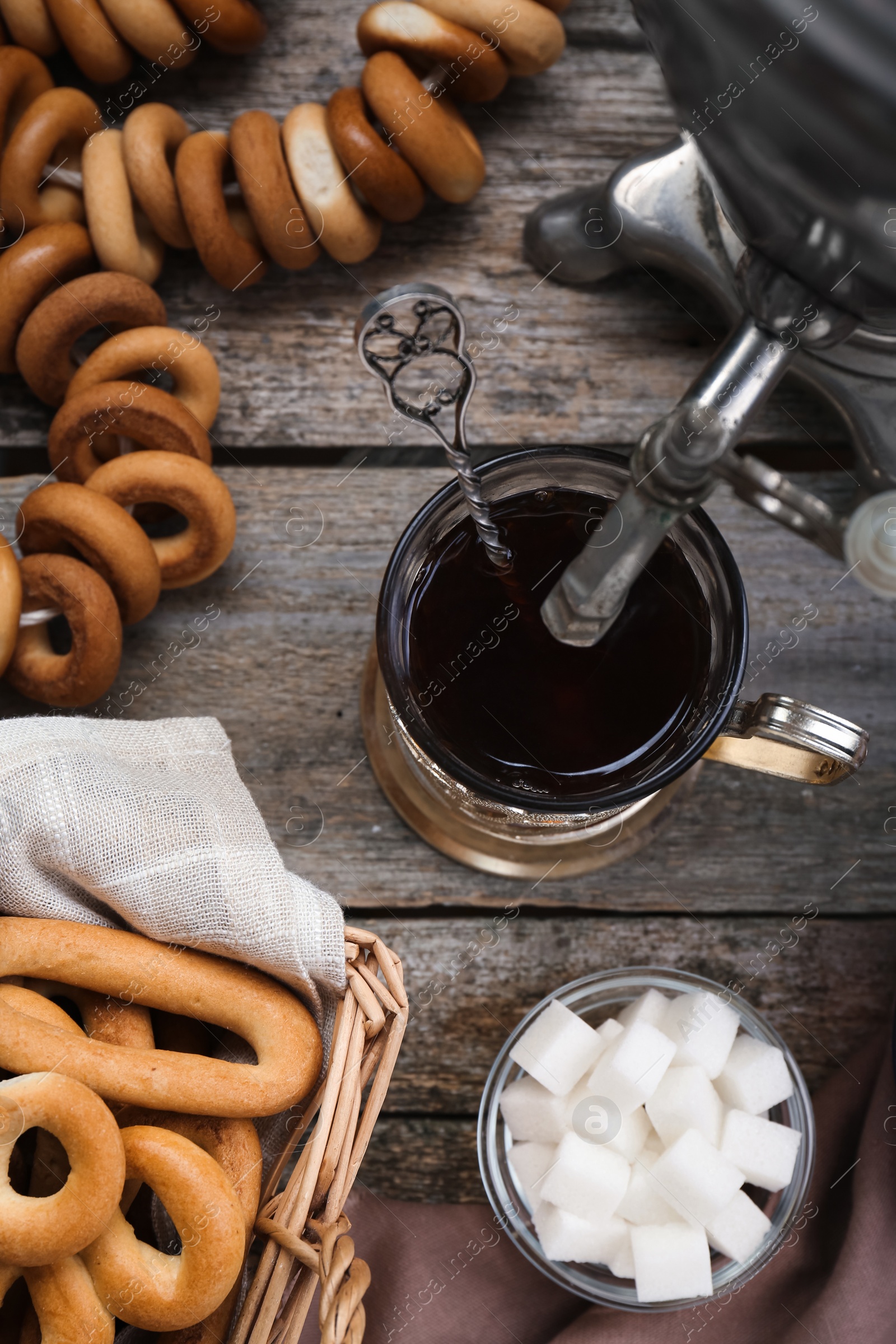 Photo of Flat lay composition with delicious ring shaped Sushki (dry bagels) and cup of tea on wooden table