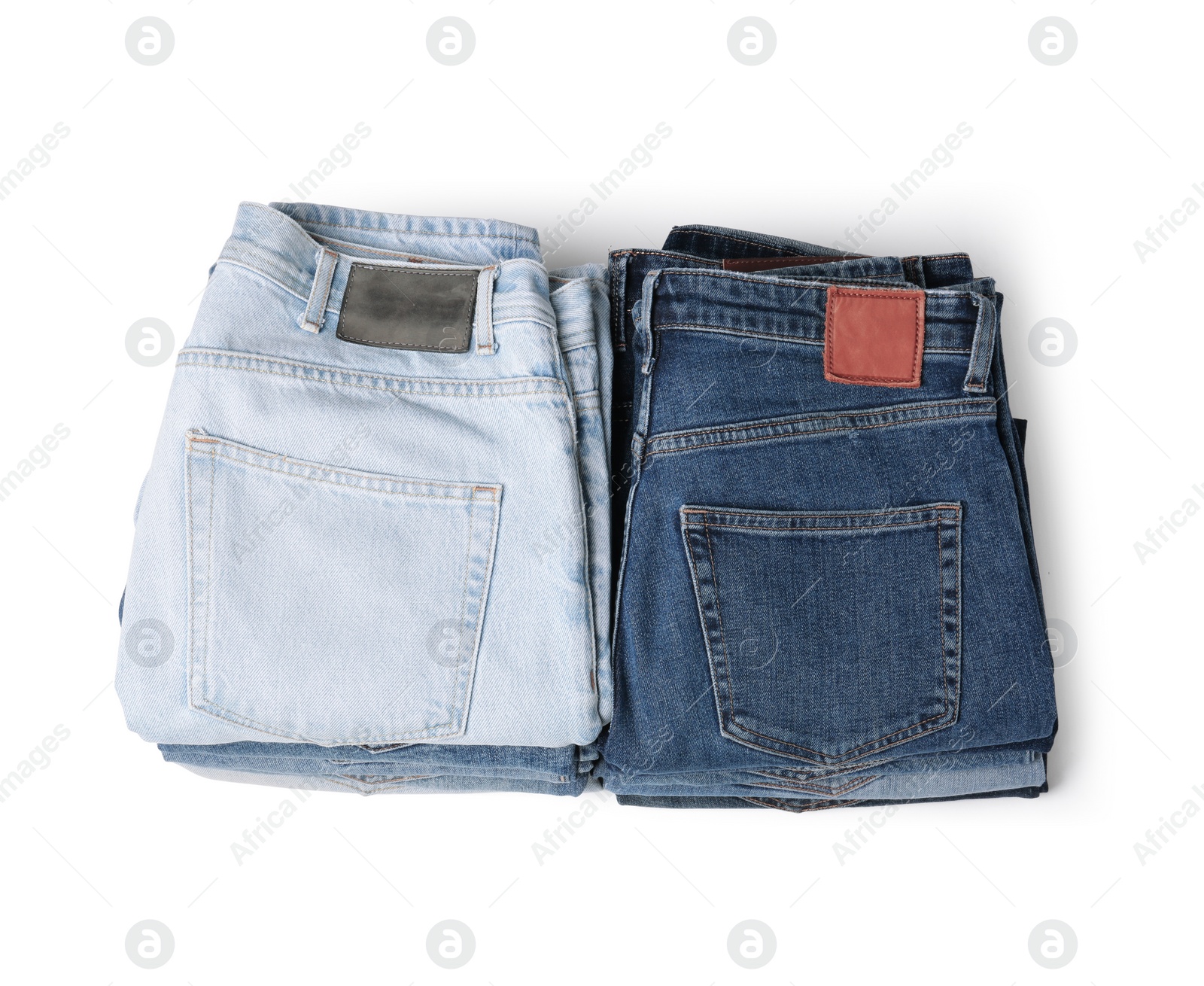 Image of Stacks of different folded jeans isolated on white, top view