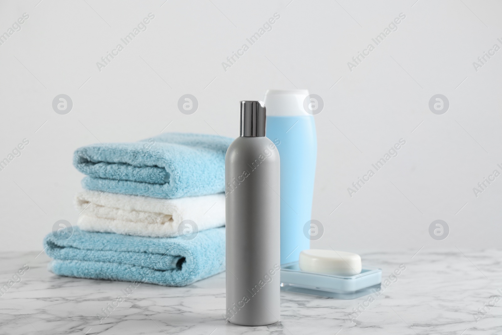 Photo of Fresh towels and toiletries on white marble table. Space for text