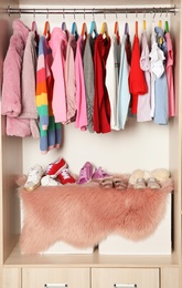 Photo of Wardrobe with stylish girl's clothes hanging on rack