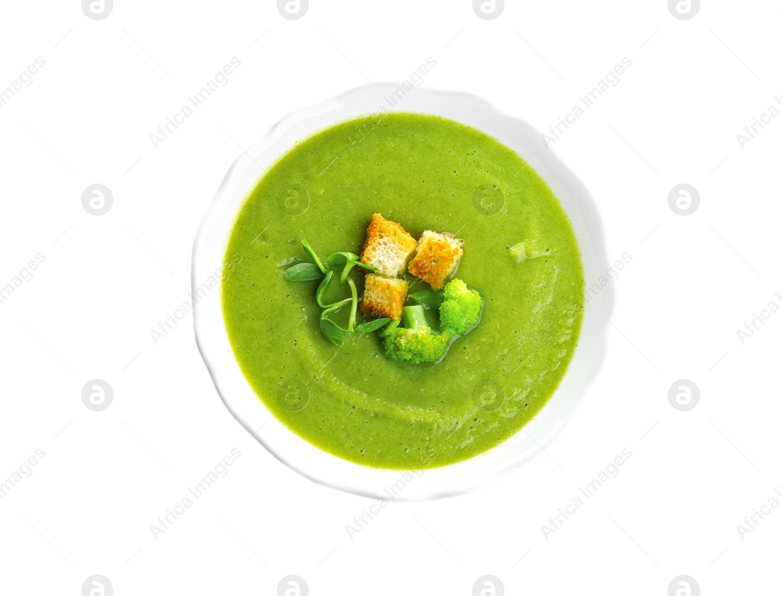 Photo of Bowl of broccoli cream soup with croutons on white background, top view