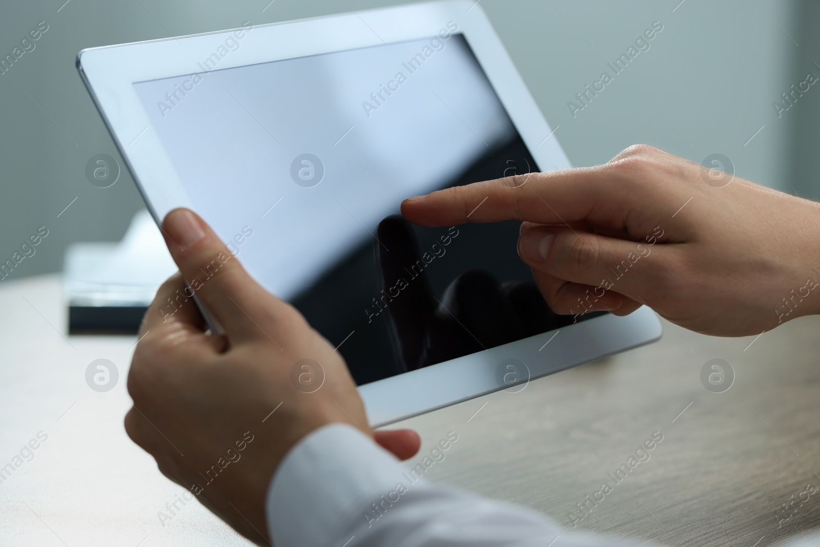 Photo of Man using tablet at wooden table, closeup