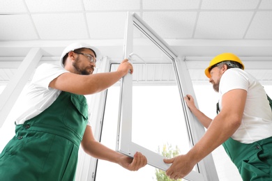 Photo of Construction workers installing new window in house