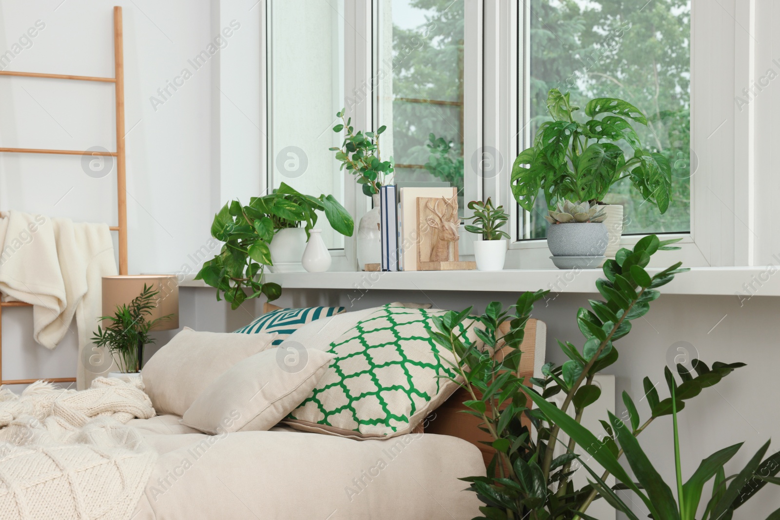 Photo of Stylish bedroom interior with beautiful house plants. Home design idea