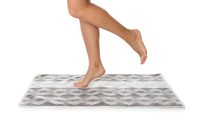 Woman standing on stylish bath mat against white background, closeup