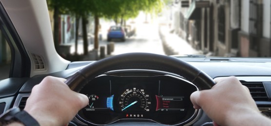 Image of Man driving modern car on city street, closeup. Banner design