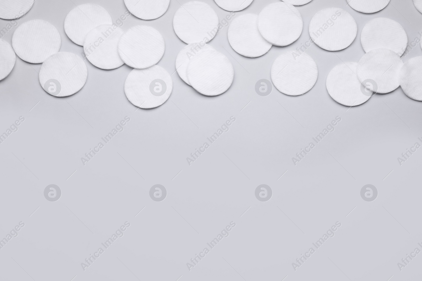Photo of Many clean cotton pads on light grey background, flat lay. Space for text