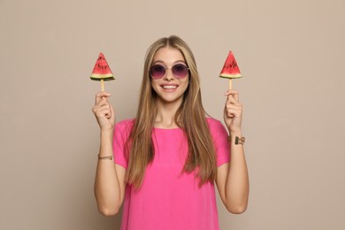 Beautiful girl with pieces of watermelon on beige background