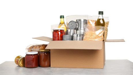 Photo of Donation box with food on light grey table against white background