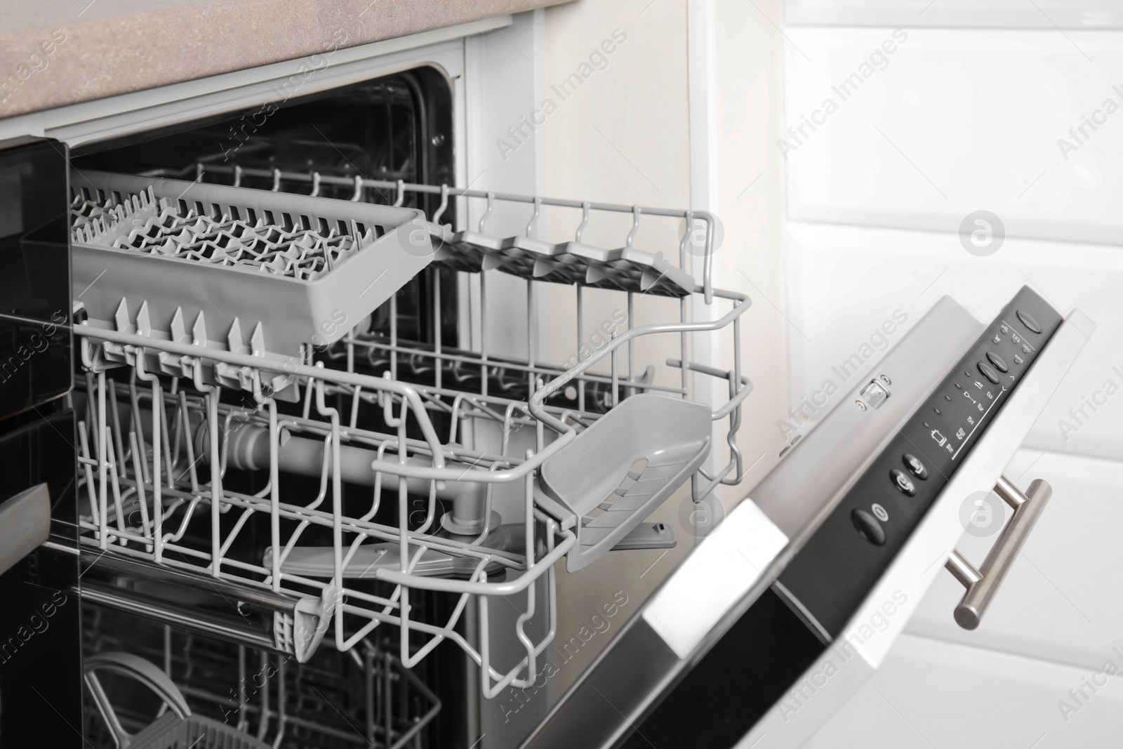 Photo of Open clean empty dishwasher in kitchen. Home appliance