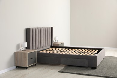 Photo of Comfortable bed with storage space for bedding under slatted base in room