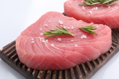 Photo of Raw tuna fillets with salt and rosemary isolated on white