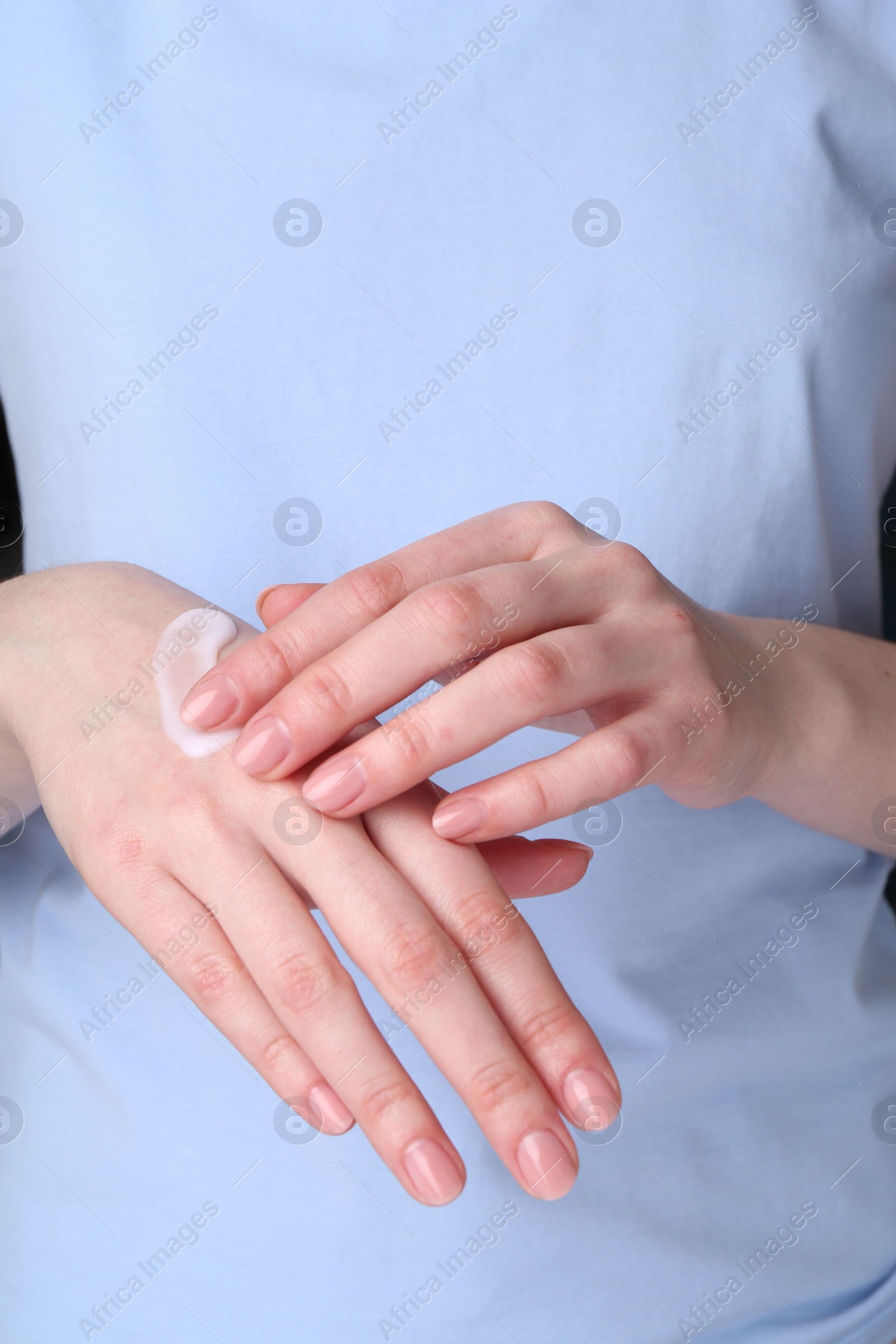 Photo of Woman applying cream on her hands, closeup