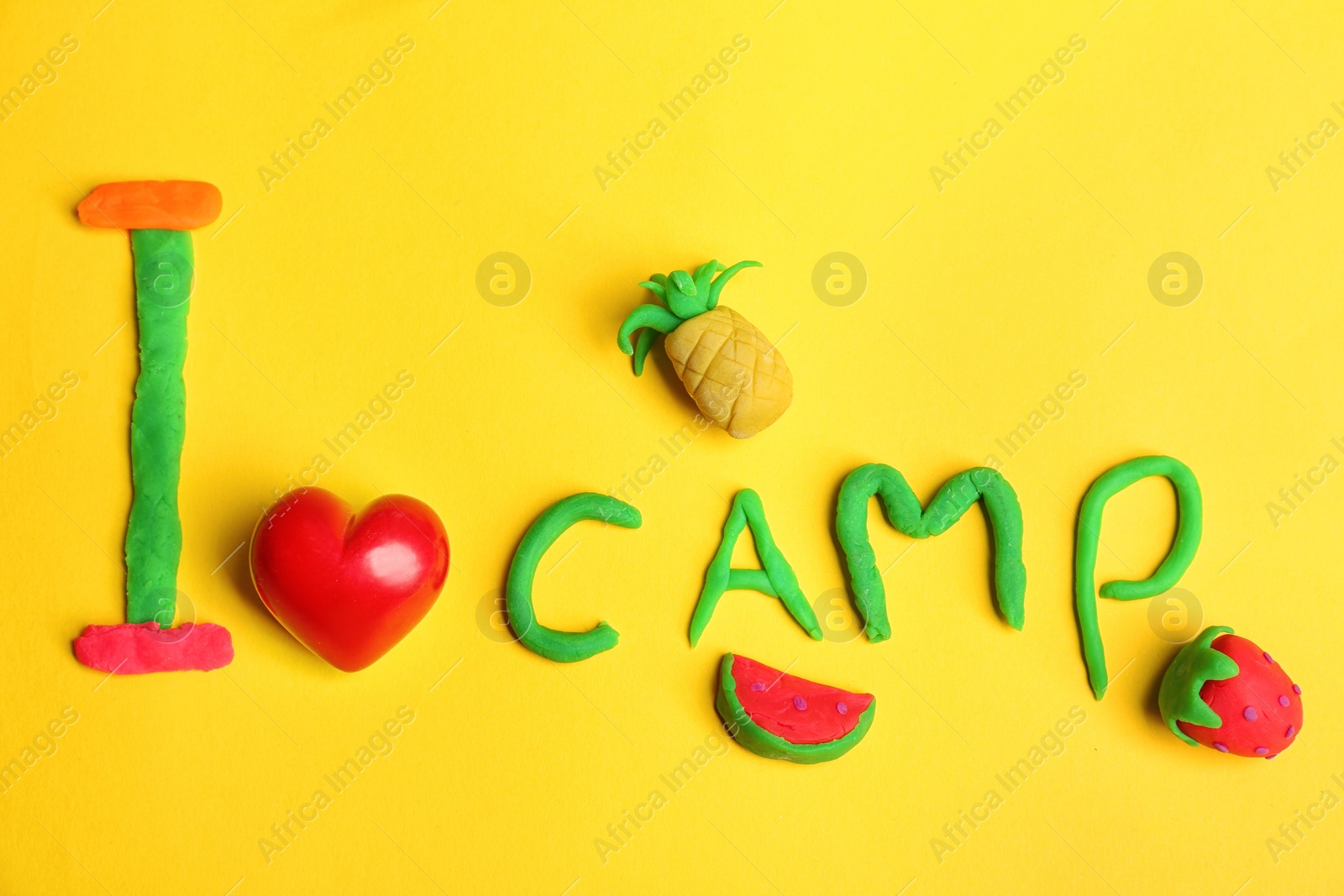 Photo of Flat lay composition with phrase I LOVE CAMP made from modelling clay on color background. Summer holidays