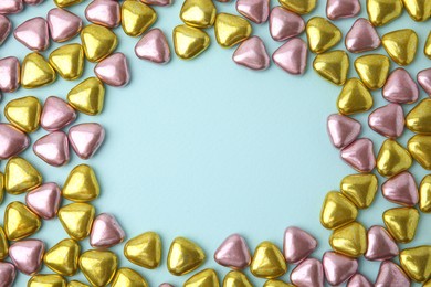 Photo of Frame made of delicious heart shaped candies on light blue background, flat lay. Space for text