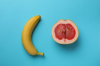 Photo of Banana and half of grapefruit on light blue background, flat lay. Sex concept