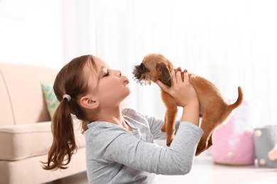 Photo of Portrait of cute girl with funny Brussels Griffon dog at home. Loyal friends