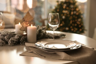 Photo of Festive table setting in room decorated for Christmas