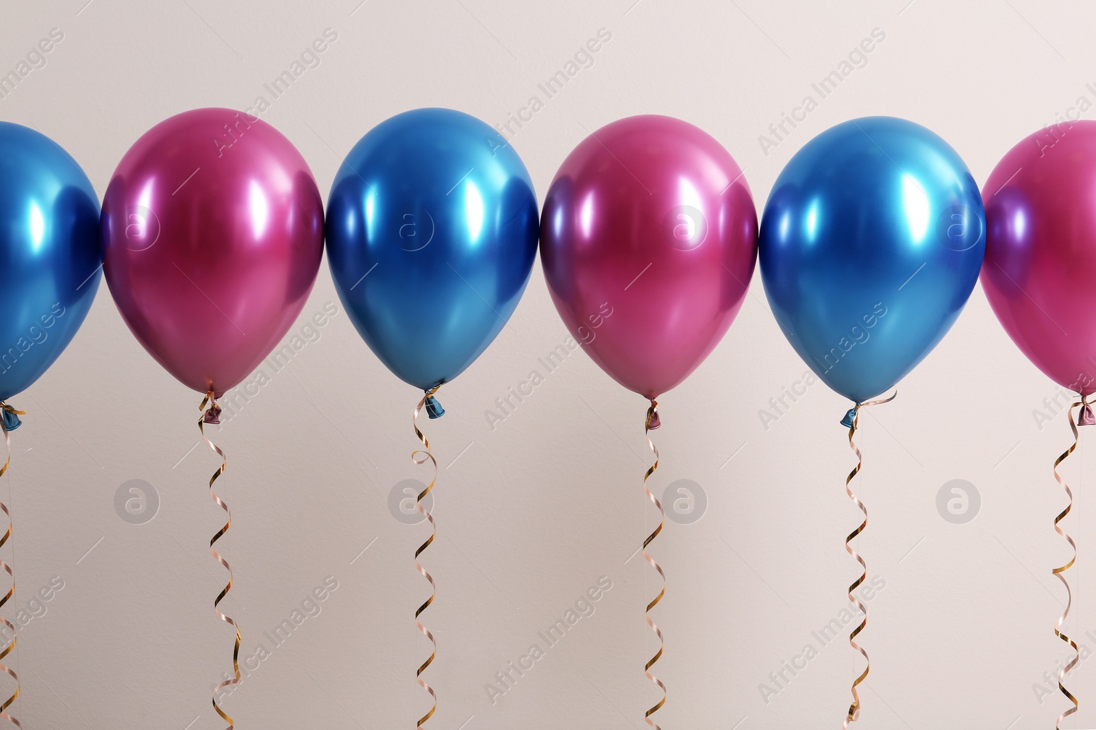 Photo of Color balloons with ribbons on white background