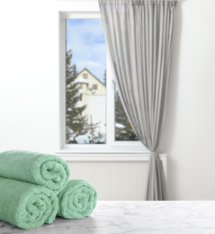 Image of Fresh towels on marble table and window with beautiful view indoors