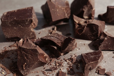 Photo of Delicious dark chocolate on grey background, closeup