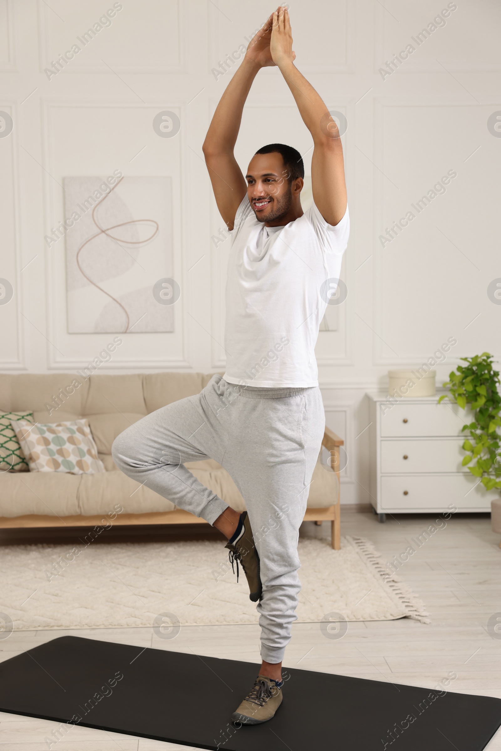 Photo of Man doing morning exercise on fitness mat at home