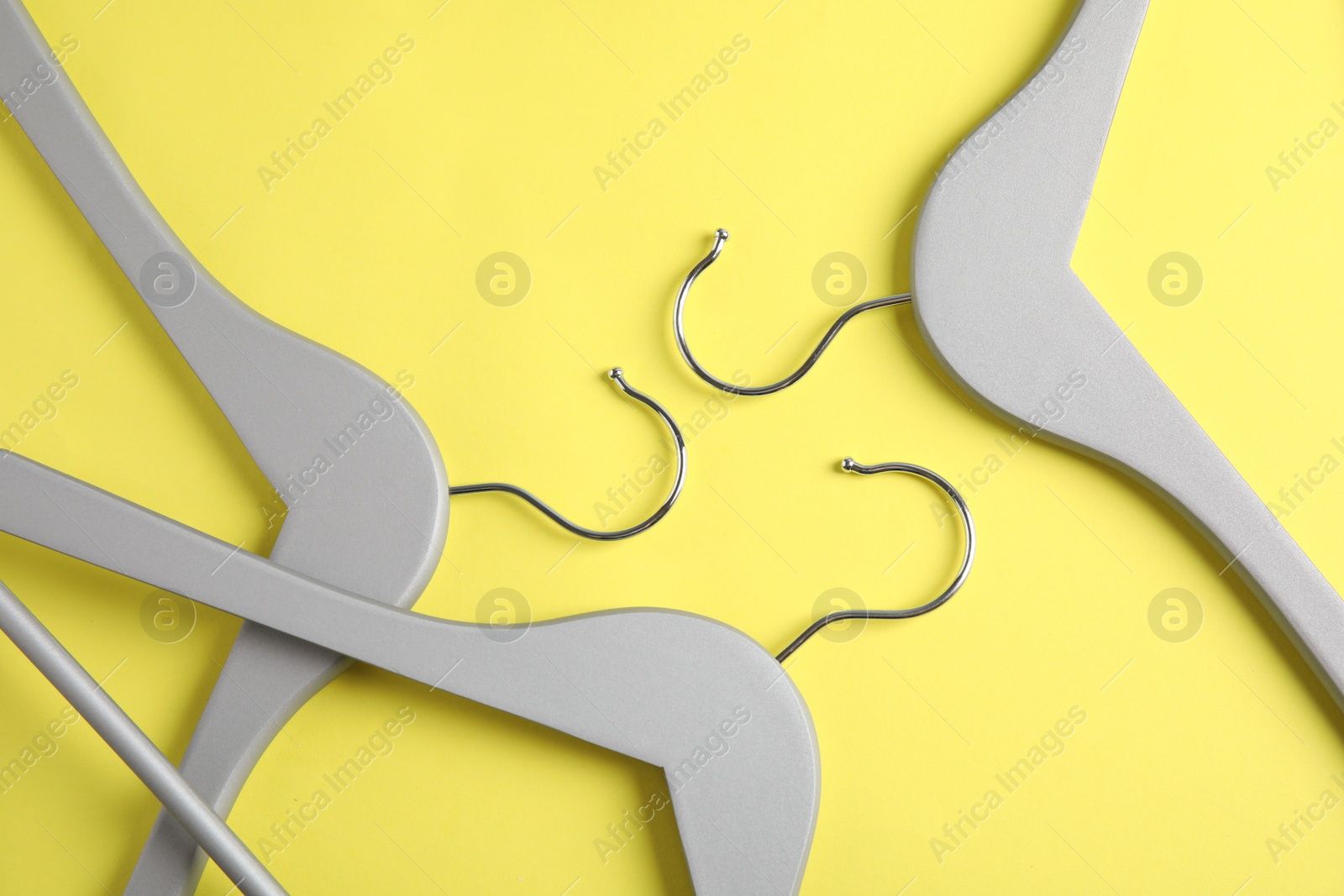 Photo of Empty wooden hangers on color background, flat lay