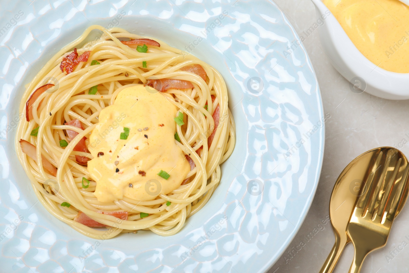 Photo of Delicious spaghetti with meat and cheese sauce served on light grey table, flat lay