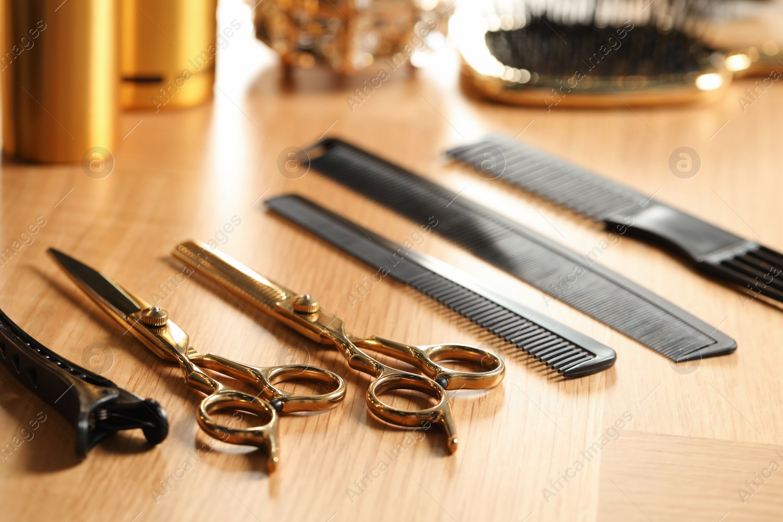 Photo of Hairdresser tools. Different scissors and combs on wooden table, closeup