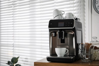 Photo of Modern coffee machine with cup in office. Space for text