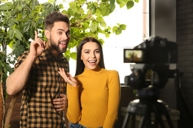 Young bloggers recording video on camera indoors