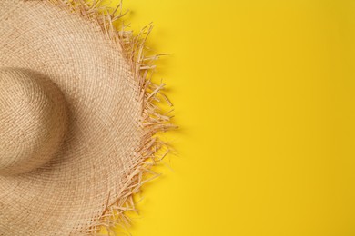 Straw hat and space for text on yellow background, top view. Stylish headdress