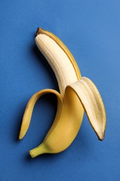 Ripe banana on blue background, top view