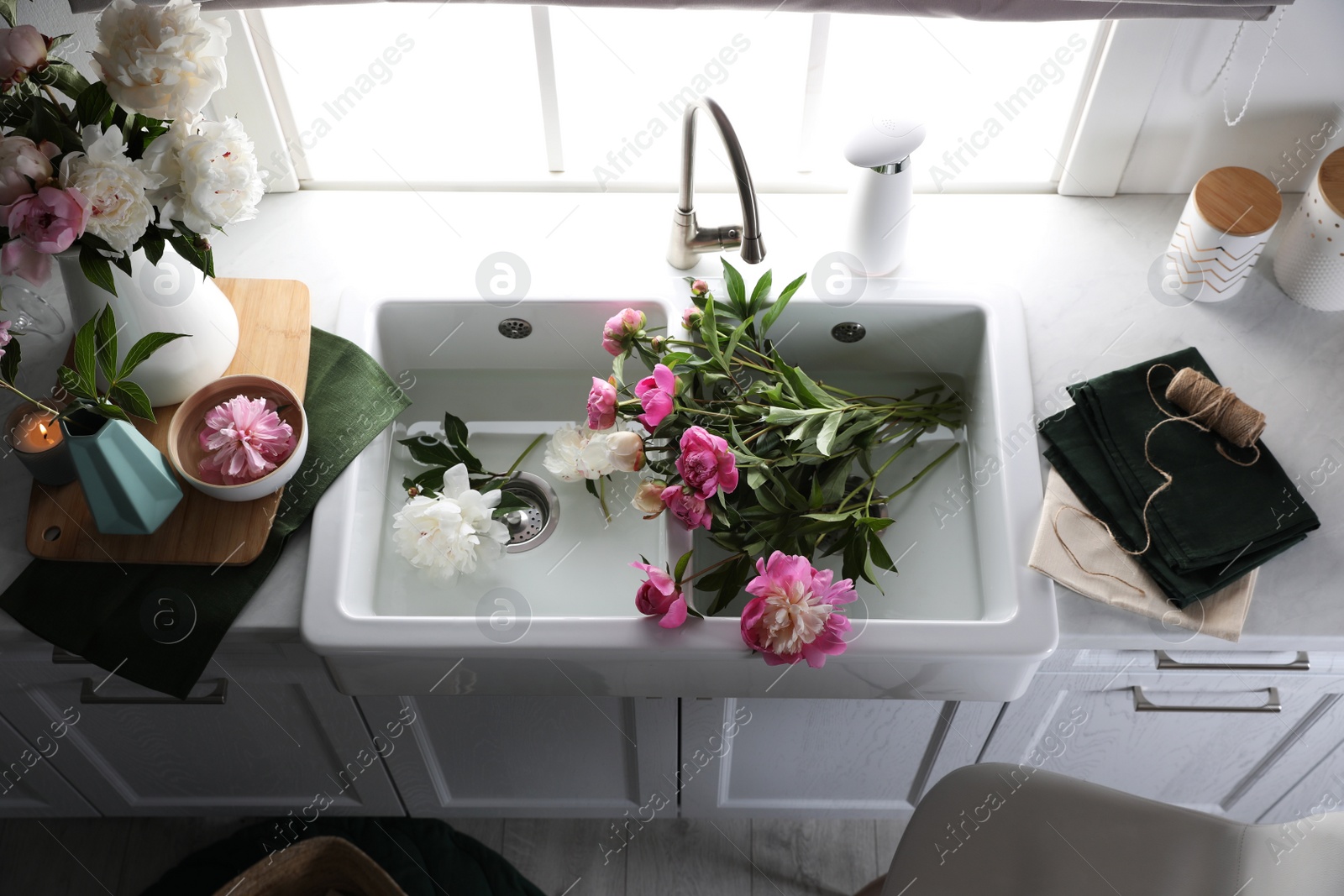 Photo of Beautiful kitchen counter design with fresh peonies, above view