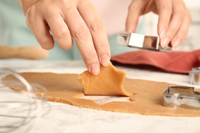 Photo of Woman making Christmas cookies at white table, closeup